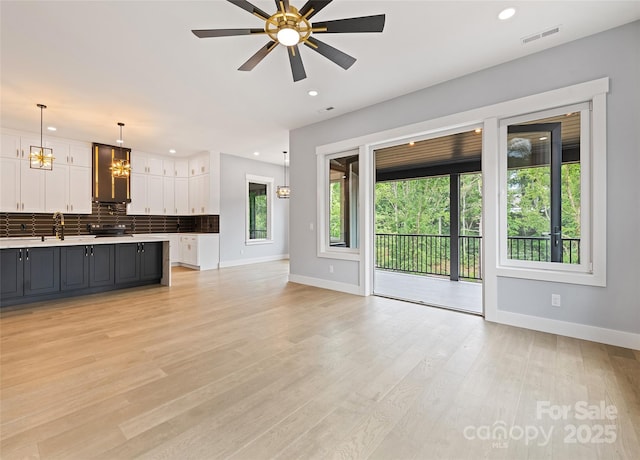 27 George Allen Rdg, Arden, NC 28704 - unfurnished living room featuring recessed lighting, a ceiling fan, light wood-type flooring, and a chandelier