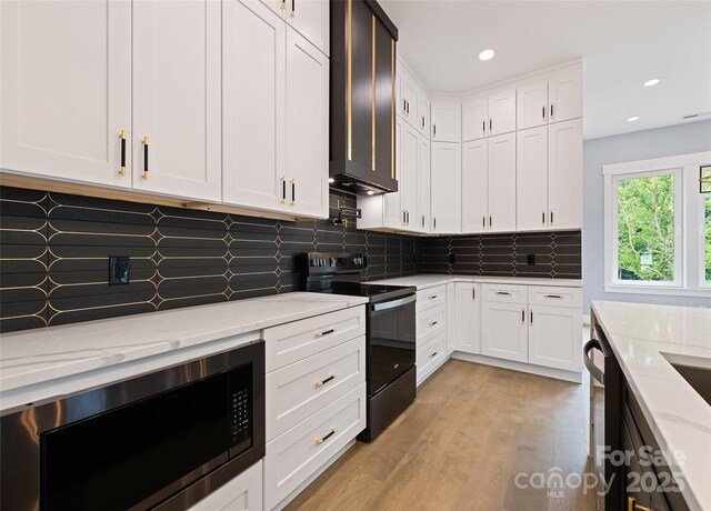 27 George Allen Rdg, Arden, NC 28704 - kitchen with black range with electric cooktop, built in microwave, white cabinetry, light stone counters, and recessed lighting