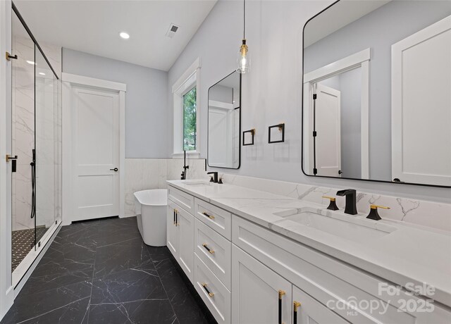 27 George Allen Rdg, Arden, NC 28704 - bathroom with marble tiled flooring, a marble finish shower, a freestanding tub, wainscoting, and double vanity