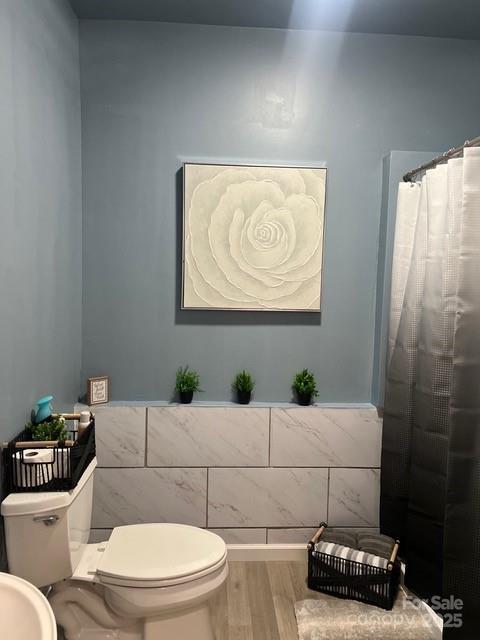 8619 Delamere Ln, Charlotte, NC 28269 - bathroom with wood finished floors and a shower with shower curtain