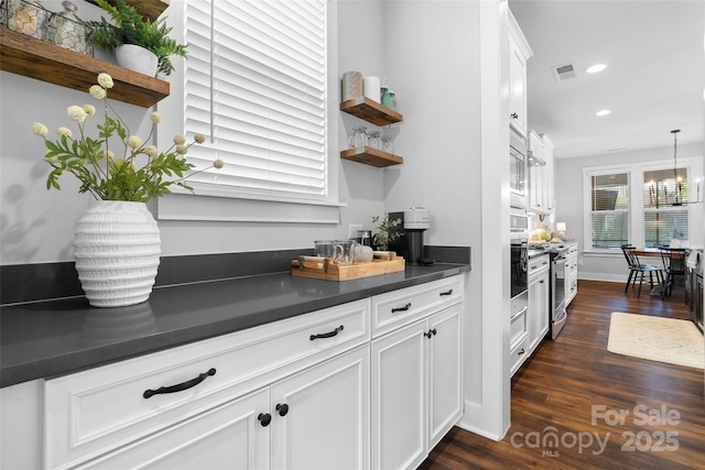 kitchen with dark wood-style flooring, dark countertops, open shelves, and visible vents