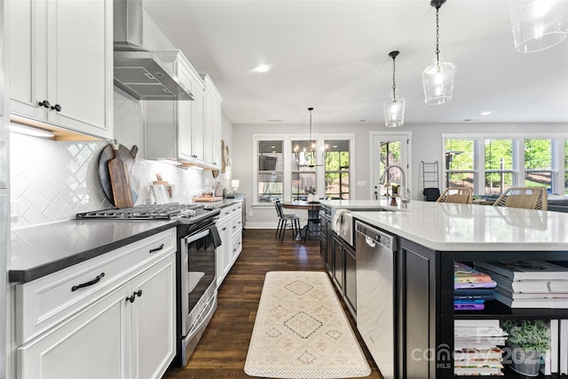 kitchen featuring backsplash, white cabinetry, wall chimney exhaust hood, dark wood finished floors, and stainless steel appliances
