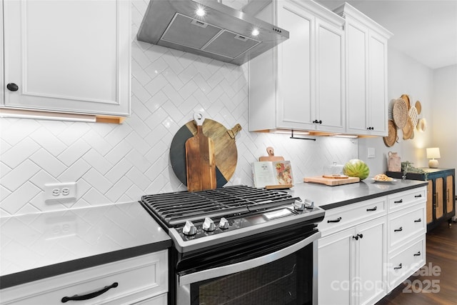 kitchen with white cabinets, stainless steel range with gas stovetop, dark countertops, ventilation hood, and backsplash