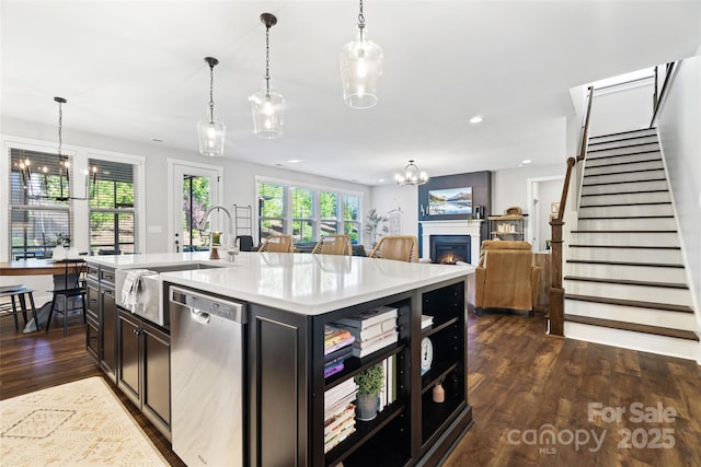 kitchen with light countertops, a sink, a chandelier, stainless steel dishwasher, and dark wood finished floors