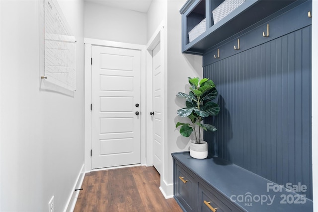 mudroom featuring dark wood-type flooring and baseboards