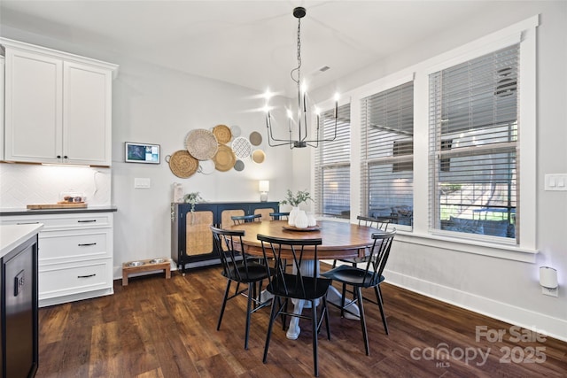 dining space with baseboards, dark wood-style flooring, and an inviting chandelier