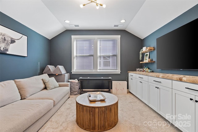 living room featuring visible vents, vaulted ceiling, and light colored carpet