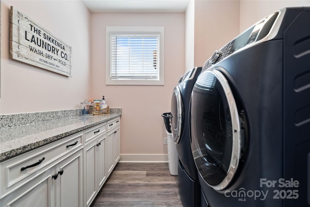 washroom featuring baseboards, separate washer and dryer, and dark wood finished floors