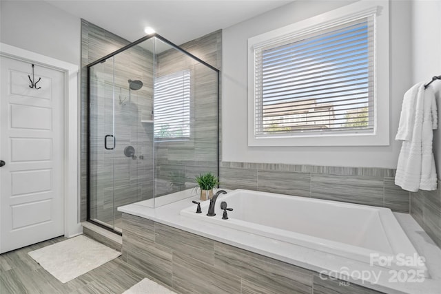 bathroom featuring a shower stall and a garden tub