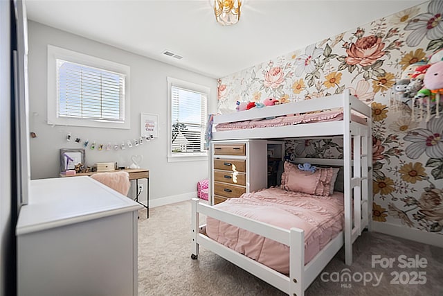 bedroom featuring baseboards, visible vents, wallpapered walls, and light colored carpet