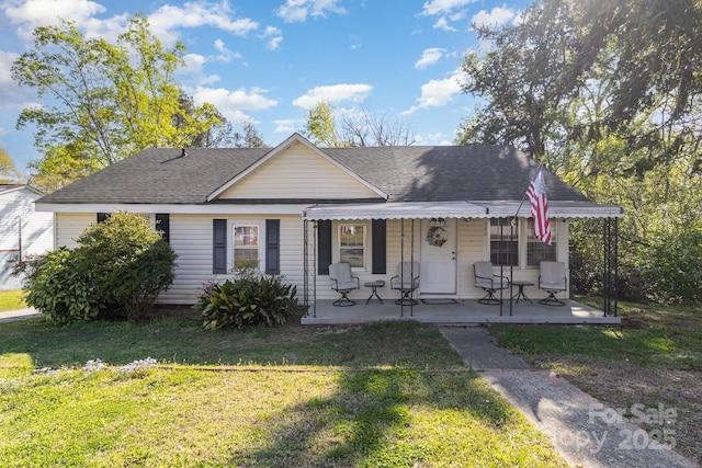 view of front of property with a front lawn and roof with shingles