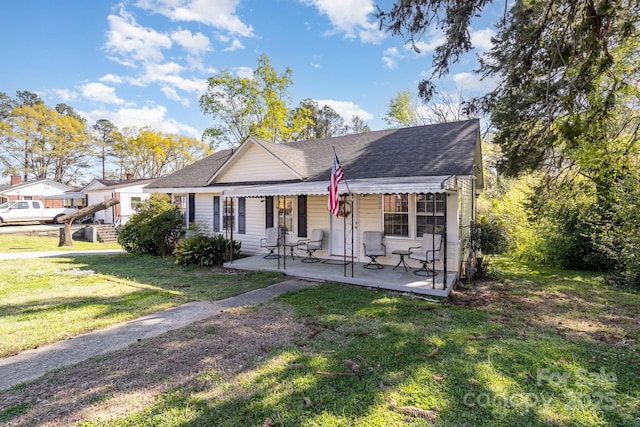 view of front of property featuring a front lawn and roof with shingles