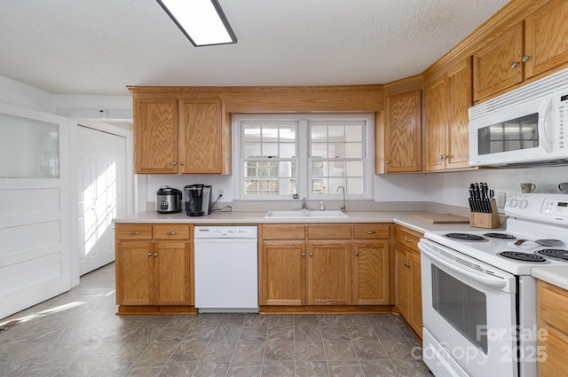 kitchen featuring light countertops, a sink, and white appliances