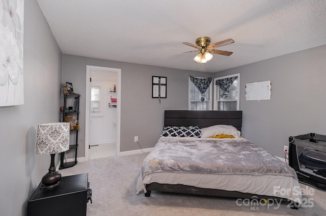 bedroom featuring a ceiling fan, carpet floors, baseboards, and a textured ceiling
