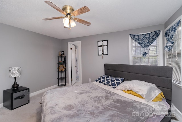 bedroom with carpet, baseboards, a textured ceiling, and ceiling fan