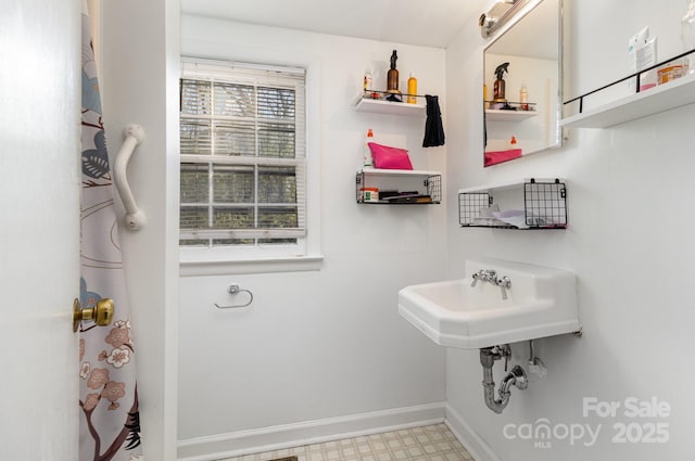 bathroom with tile patterned floors, baseboards, and a sink