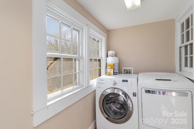 washroom featuring a healthy amount of sunlight, laundry area, and washer and clothes dryer