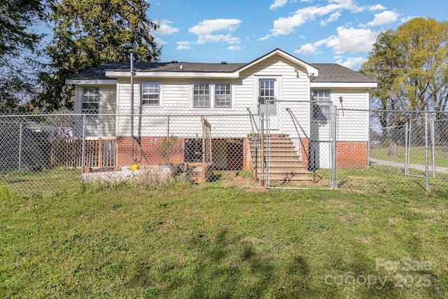 rear view of property featuring roof with shingles, a gate, fence, and a yard
