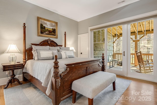 bedroom featuring visible vents, light wood finished floors, baseboards, and access to exterior
