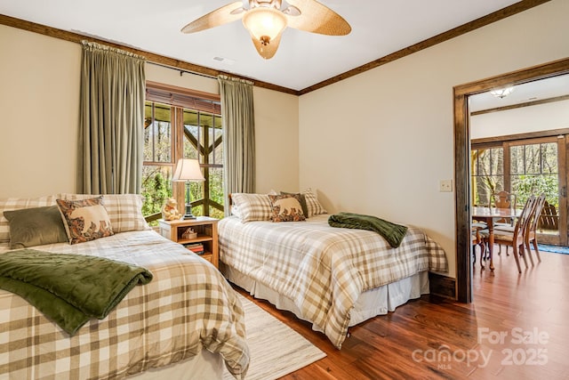 bedroom featuring crown molding, a ceiling fan, and wood finished floors