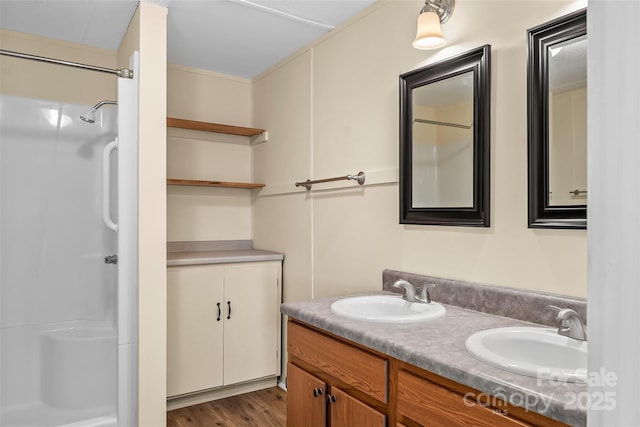 full bathroom featuring double vanity, a sink, and walk in shower