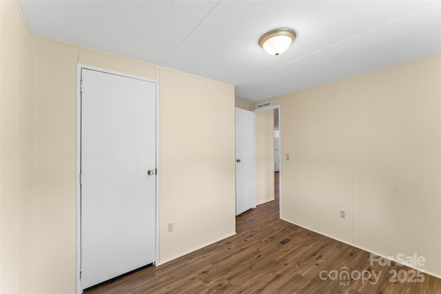 unfurnished bedroom with visible vents and wood finished floors