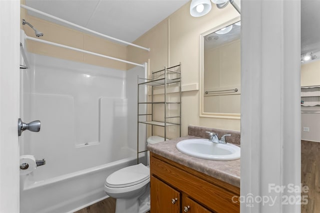 bathroom with toilet, shower / bath combination, vanity, and wood finished floors