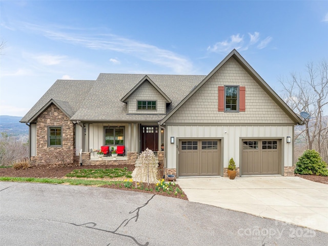 view of front of house featuring stone siding, a garage, concrete driveway, board and batten siding, and roof with shingles