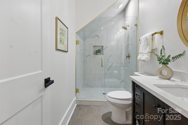 bathroom featuring a marble finish shower, toilet, tile patterned floors, and vanity