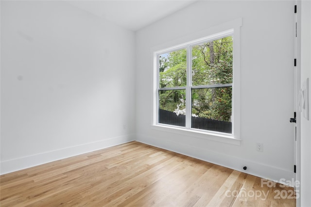 empty room featuring light wood-style flooring and baseboards