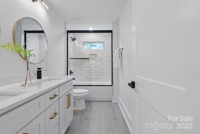 full bath featuring toilet, a sink, double vanity, and enclosed tub / shower combo