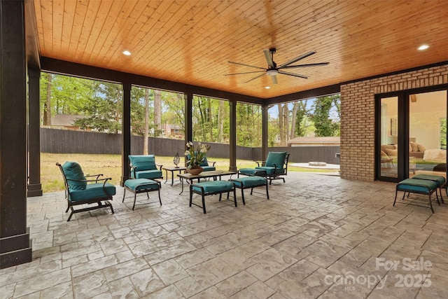 sunroom with a ceiling fan and an outdoor living space with a fire pit