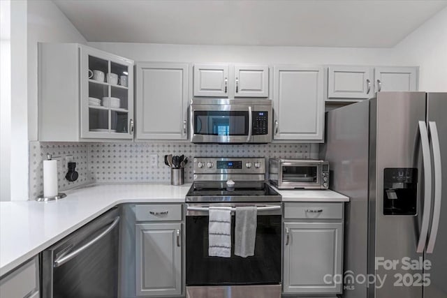 17143 Red Feather Dr, Charlotte, NC 28277 - kitchen with glass insert cabinets, gray cabinets, tasteful backsplash, and appliances with stainless steel finishes