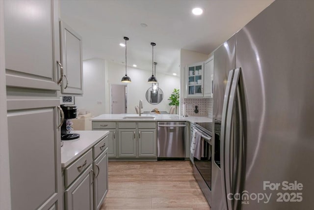 17143 Red Feather Dr, Charlotte, NC 28277 - kitchen featuring a sink, a peninsula, gray cabinetry, lofted ceiling, and stainless steel appliances