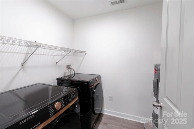 17143 Red Feather Dr, Charlotte, NC 28277 - laundry room with washer and clothes dryer, wood finished floors, laundry area, baseboards, and visible vents