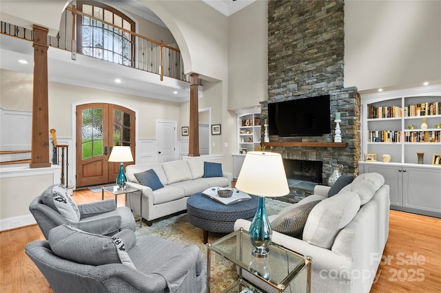 19040 Mary Ardrey Cir, Cornelius, NC 28031 - living area with decorative columns, a towering ceiling, crown molding, wood finished floors, and a stone fireplace