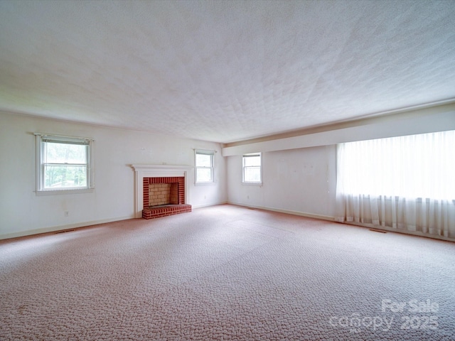 167 Cedar Ln, Troutman, NC 28166 - unfurnished living room featuring carpet floors, a brick fireplace, baseboards, and a textured ceiling