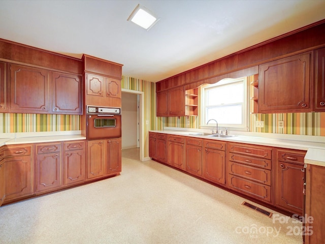167 Cedar Ln, Troutman, NC 28166 - kitchen featuring wall oven, wallpapered walls, open shelves, a sink, and light countertops