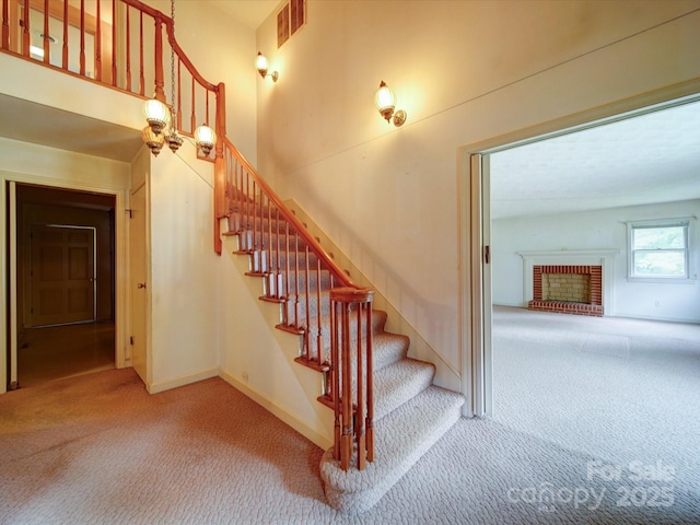 167 Cedar Ln, Troutman, NC 28166 - stairway with carpet floors, a fireplace, baseboards, and a high ceiling