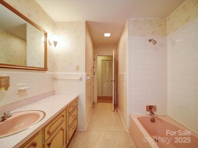 167 Cedar Ln, Troutman, NC 28166 - bathroom with wallpapered walls, vanity, tile walls, shower / bath combination, and a wainscoted wall