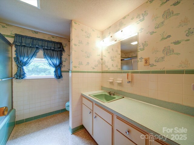 167 Cedar Ln, Troutman, NC 28166 - full bath featuring wallpapered walls, a wainscoted wall, vanity, toilet, and a shower with door