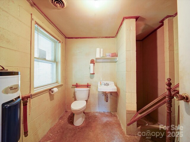 167 Cedar Ln, Troutman, NC 28166 - bathroom with water heater, toilet, concrete floors, a sink, and concrete block wall