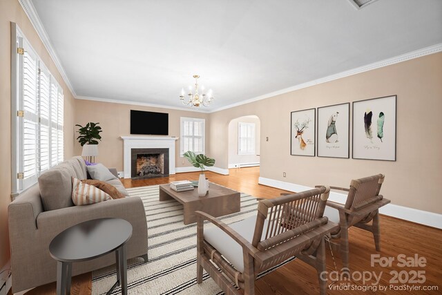 431 Sullivan Rd, Statesville, NC 28677 - living area featuring ornamental molding, baseboards, light wood-style floors, a chandelier, and a fireplace with flush hearth