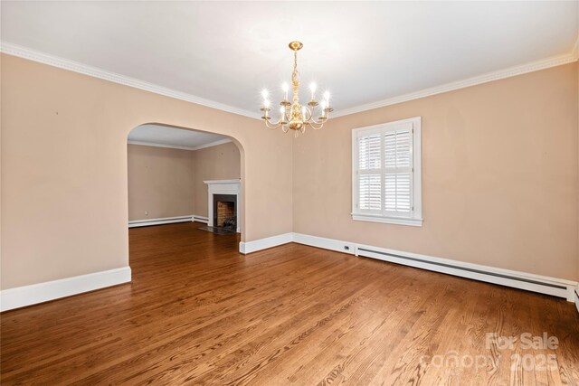 431 Sullivan Rd, Statesville, NC 28677 - empty room featuring a baseboard radiator, arched walkways, wood finished floors, crown molding, and a chandelier