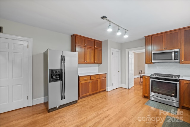 431 Sullivan Rd, Statesville, NC 28677 - kitchen with stainless steel appliances, light countertops, light wood-type flooring, backsplash, and brown cabinets