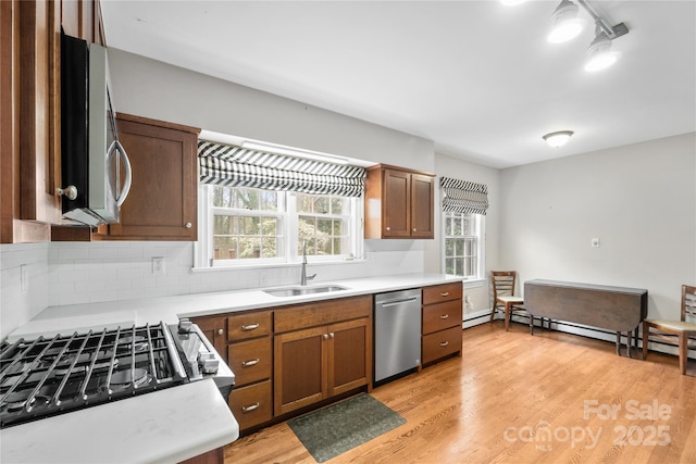 431 Sullivan Rd, Statesville, NC 28677 - kitchen featuring appliances with stainless steel finishes, a sink, light countertops, tasteful backsplash, and brown cabinetry