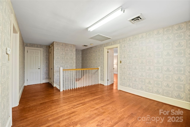 431 Sullivan Rd, Statesville, NC 28677 - unfurnished room with wood finished floors, wallpapered walls, and baseboards