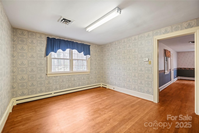 431 Sullivan Rd, Statesville, NC 28677 - empty room with wallpapered walls, wood finished floors, a baseboard radiator, and baseboards