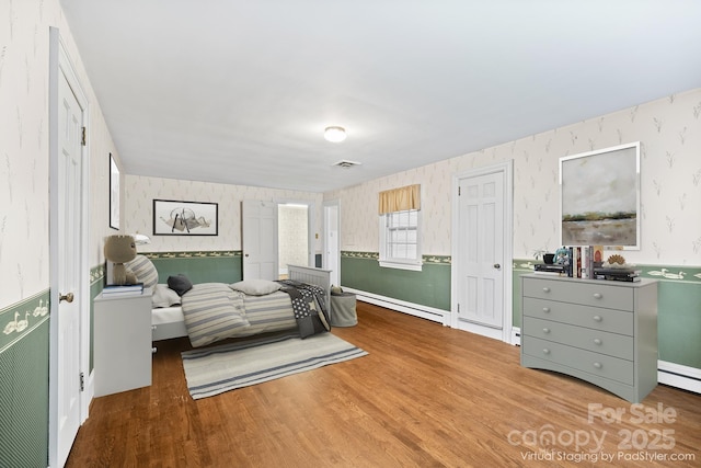 431 Sullivan Rd, Statesville, NC 28677 - bedroom with wallpapered walls, wood finished floors, a baseboard heating unit, and baseboards