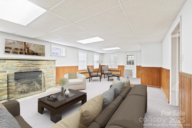 431 Sullivan Rd, Statesville, NC 28677 - carpeted living area with a wainscoted wall, a paneled ceiling, wood walls, a fireplace, and radiator heating unit